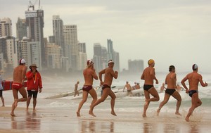 Daniel Moodie (facing camera) heads into the Kurrawa Beach surf during his ironman heat today.